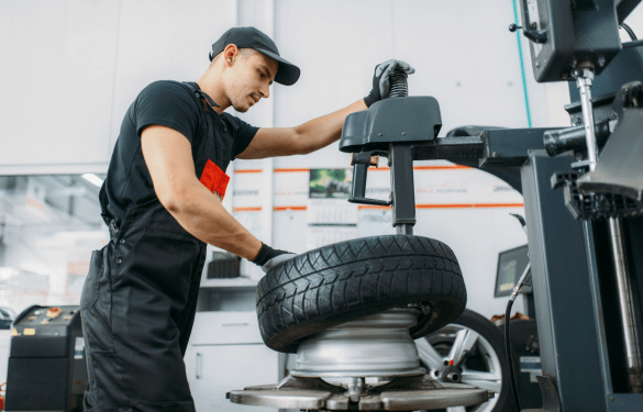 Tire technician inspecting a tire at Tatlow Tire, showcasing professional automotive tire services i.