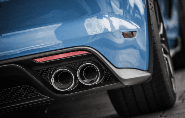 Close-up of a sporty car's dual exhaust pipes and rear bumper.