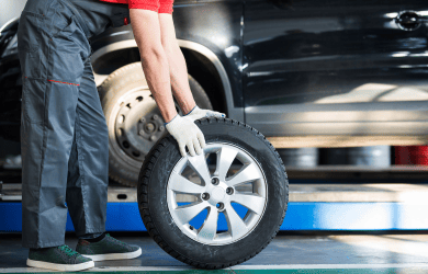Technician changing a car tire at Tatlow Tire in 2024.