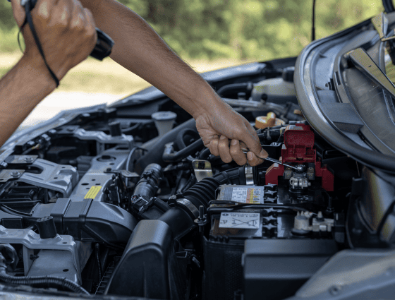 Mechanic inspecting car engine for repairs at Teays Valley Auto.