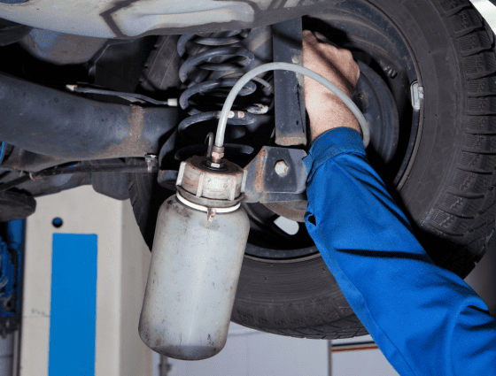 Technician inspecting vehicle suspension system during repair.