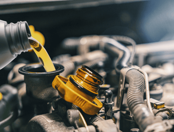 Engine oil being poured into a car engine during maintenance.