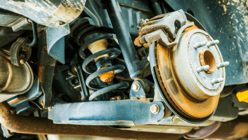 Close-up of vehicle suspension showing shocks and struts for repair.