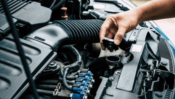 Technician performing general maintenance on a car engine.