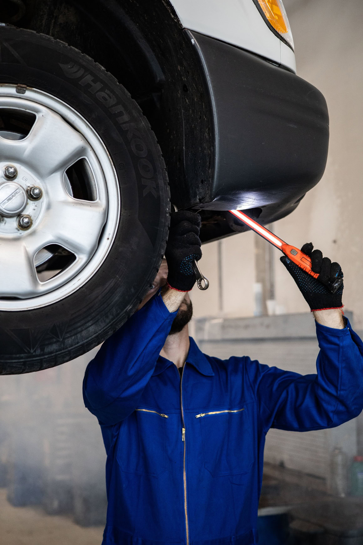 Technician inspecting vehicle underside during state inspection at Teays Valley Auto.