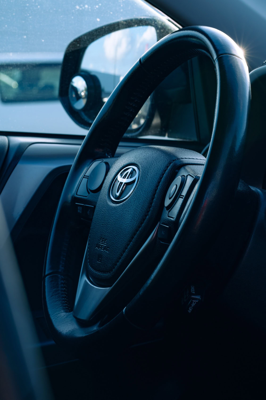 Close-up of Toyota steering wheel inside a vehicle for auto repair.