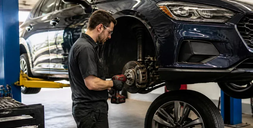 Auto mechanic working on a car's brake system at Teays Valley Auto.