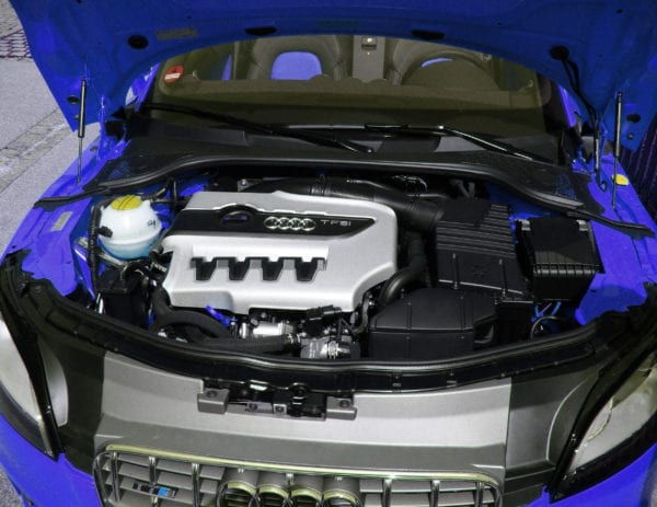 Audi engine bay with visible engine components and branding.