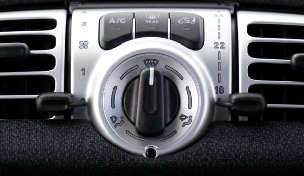 Vehicle climate control panel with temperature and airflow settings.