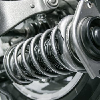 Close-up of vehicle suspension coil spring and shock absorber.