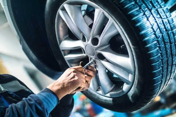Technician changing a car tire at Techline Motors, NAPA Autopro.