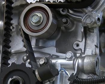 Close-up of timing belt and engine components at Techline Motors.