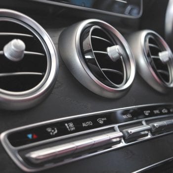 Close-up of car air conditioning vents and control panel.