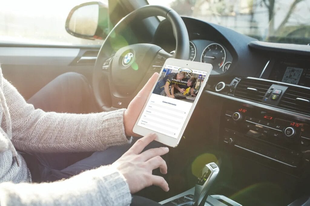 Person using smartphone inside a car at Techline Motors.
