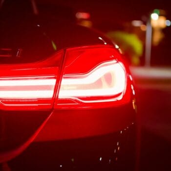 Close-up of a car's illuminated taillight at night.