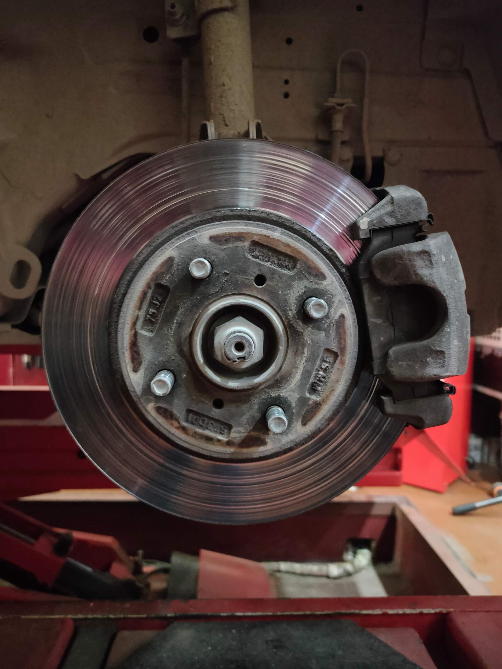 Close-up of a disc brake rotor and caliper at Techline Motors.