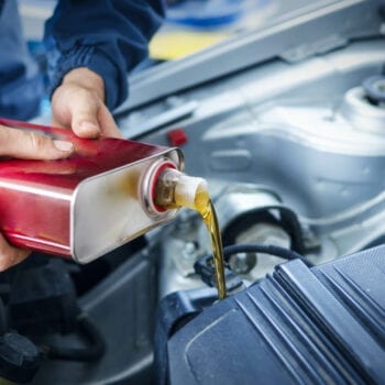 Pouring synthetic motor oil into a car engine at Techline Motors.