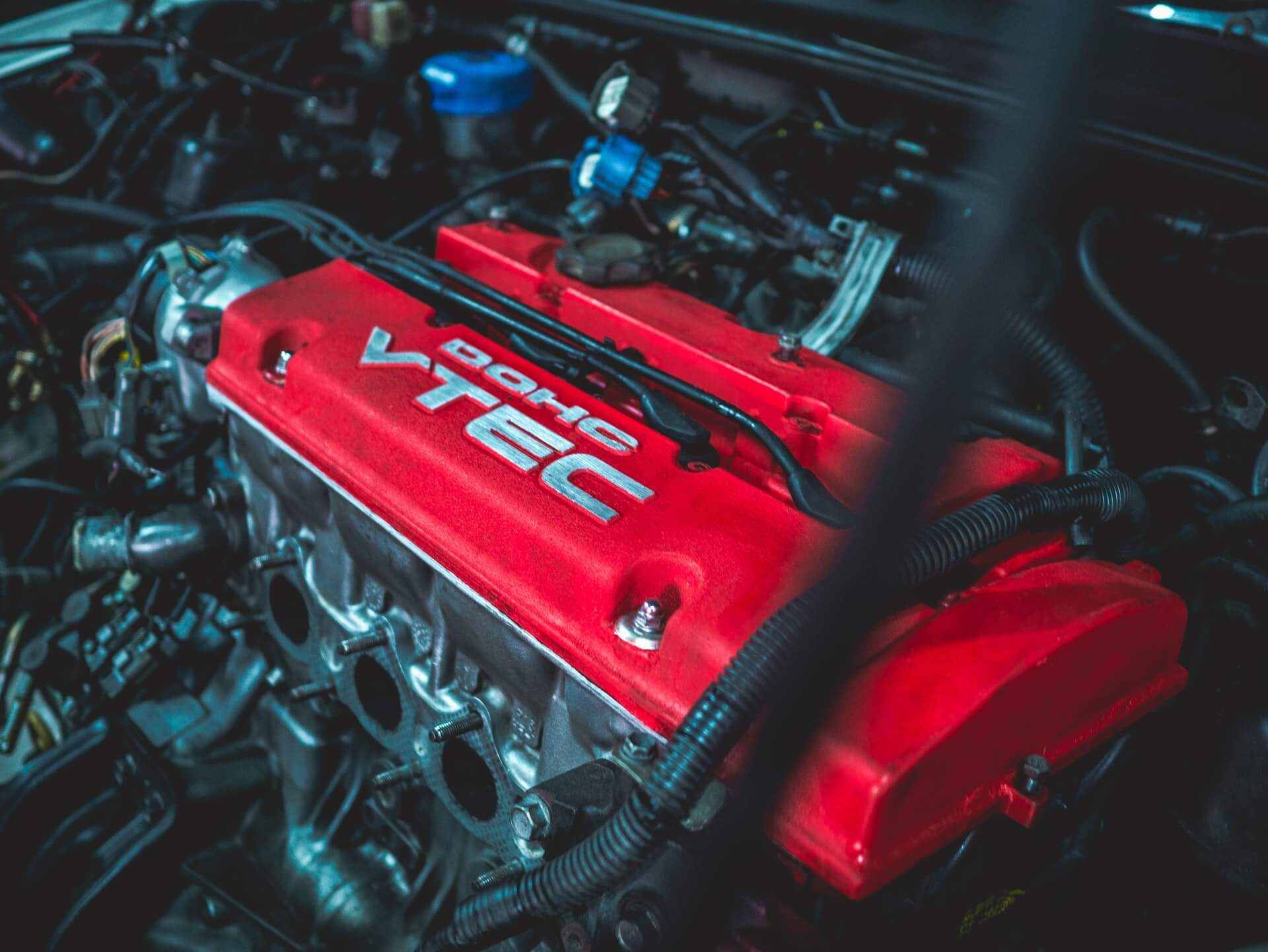Red VTEC engine with Honda badge in a car engine bay.