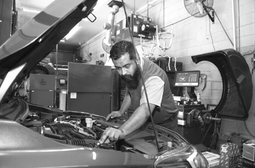 Skilled mechanic working on car engine at Telegraph Auto Repair.