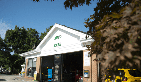 Auto repair shop with open garage and service bays in a suburban area.