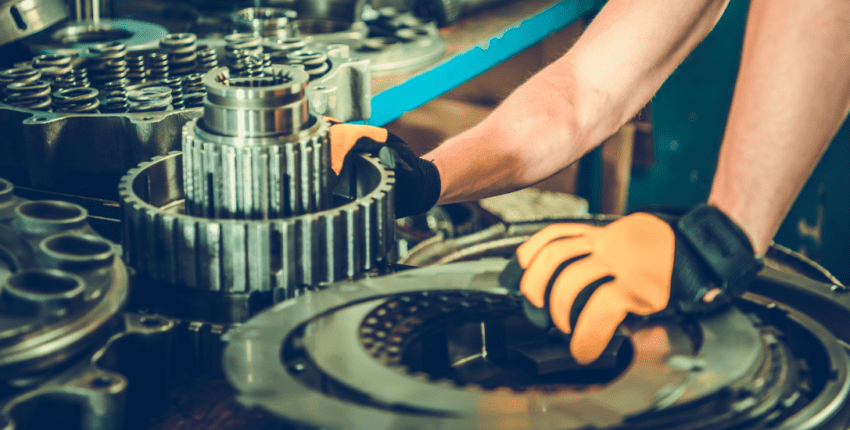 Technician repairing a transmission gearbox with precision tools at Telegraph Auto Repair.