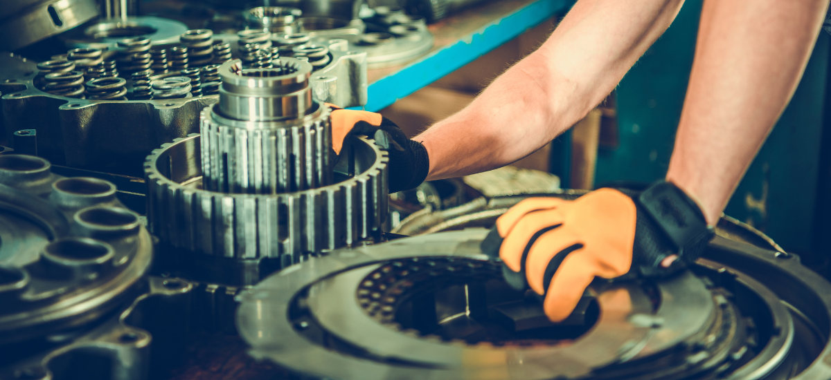 Technician repairing a transmission gearbox with precision tools at Telegraph Auto Repair.