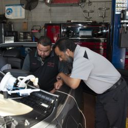 Auto repair technicians diagnosing car engine issues at Telegraph Auto Repair.