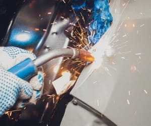 Welding process on a car with sparks at Texxaco Racing workshop.