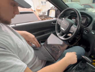Man working on car tuning inside a vehicle at Texxaco Racing.
