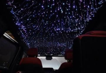 Interior view of a luxury vehicle with a starry LED ceiling lighting system.