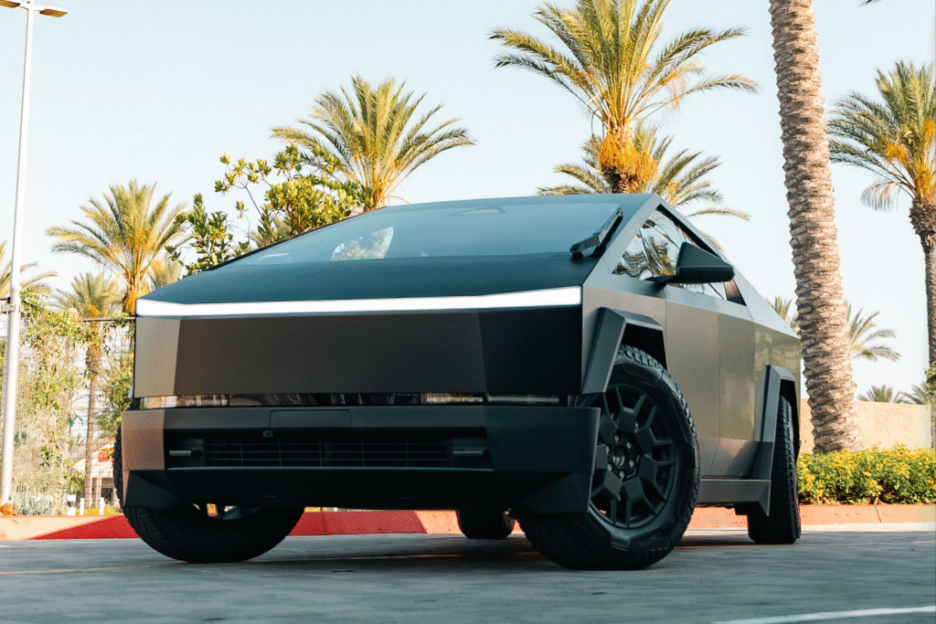 Futuristic electric car with sleek, modern design parked outdoors among palm trees.