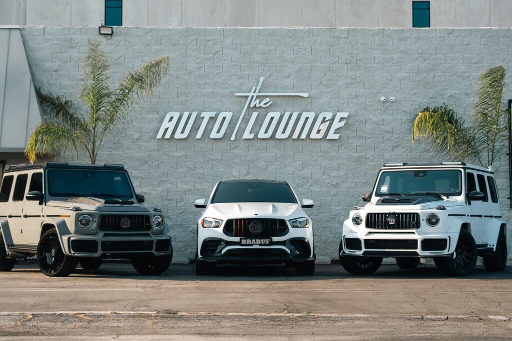 Auto Lounge luxury SUVs parked outside showroom.