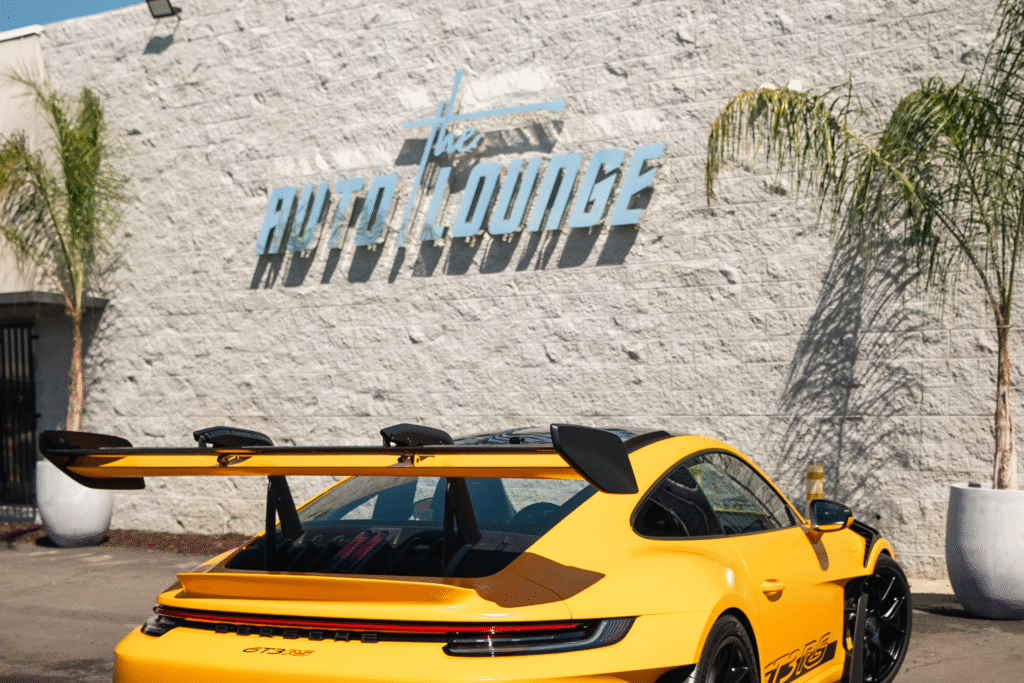Yellow Porsche 911 Turbo S parked outside The Auto Lounge showroom.