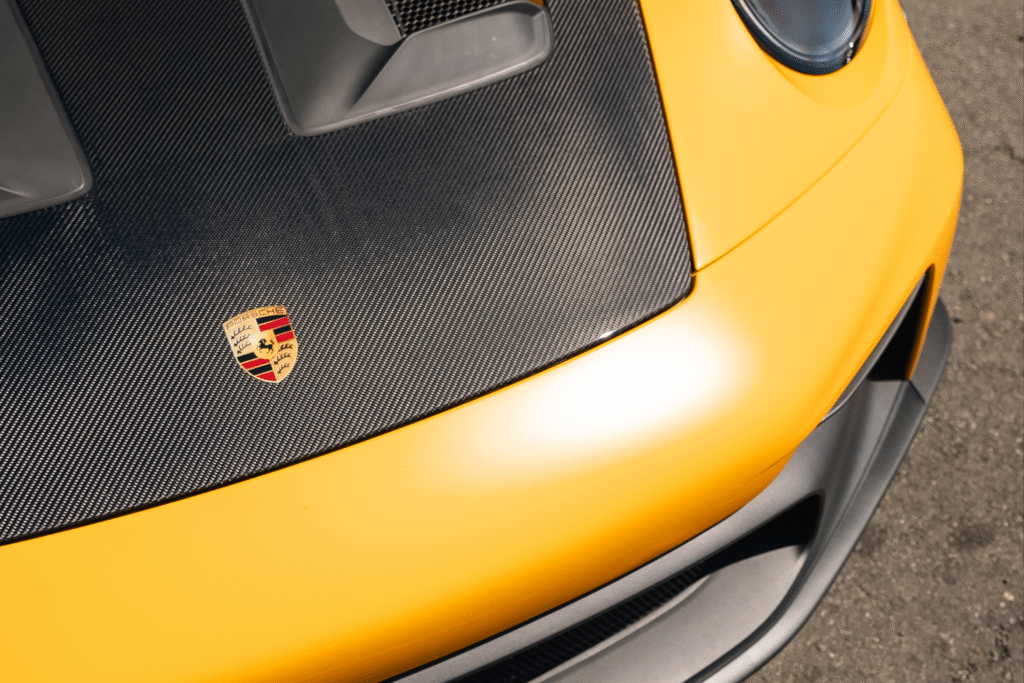 Close-up of a yellow Porsche sports car with carbon fiber details.