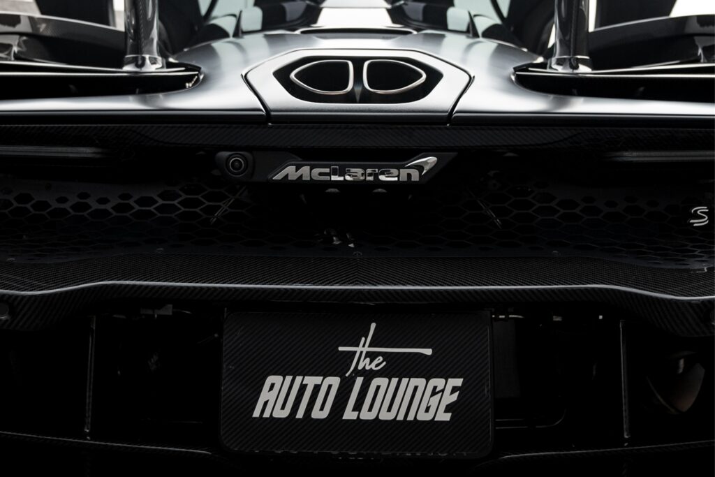 Close-up of a McLaren supercar's front with sleek design and carbon fiber details.