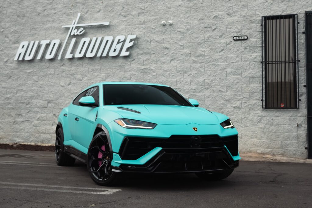 Lamborghini Urus SUV parked outside The Auto Lounge dealership.