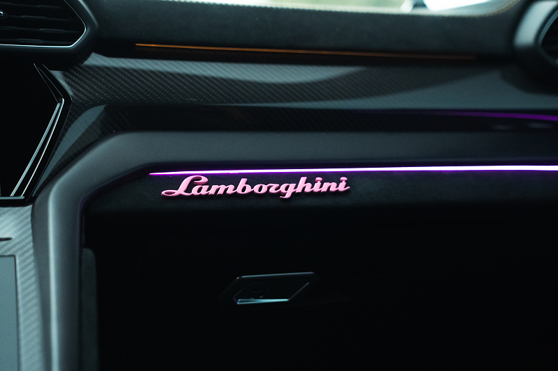 Lamborghini dashboard illuminated with pink ambient lighting.
