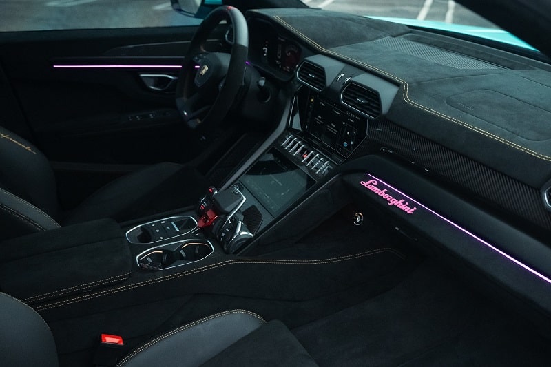 Luxury car interior with advanced dashboard and custom lighting at The Auto Lounge.
