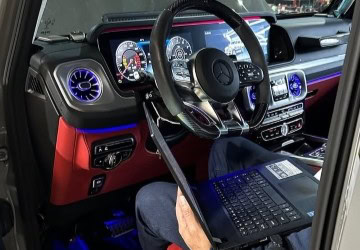 Interior dashboard with digital displays and steering wheel in a luxury vehicle.