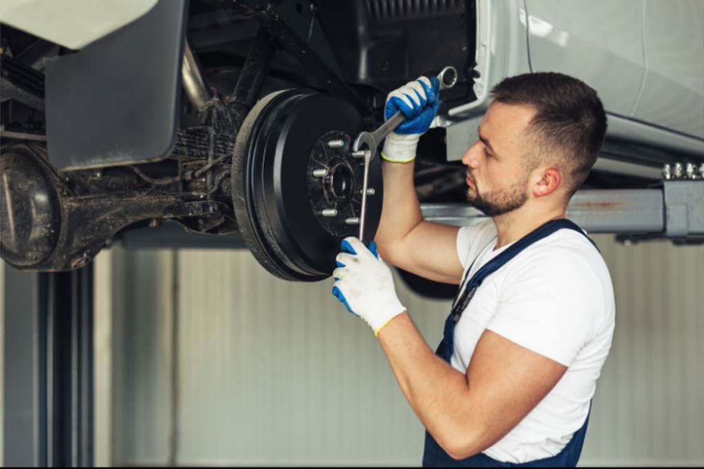 Mechanic inspecting car brake system for safety and maintenance.