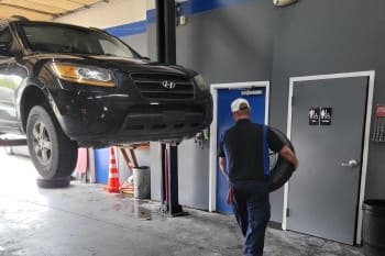 Vehicle lifted for maintenance at The Car People auto repair shop.