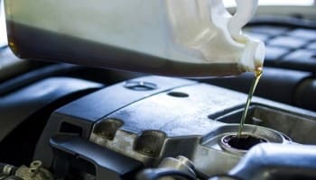 Car engine oil being poured during maintenance at The Car People.