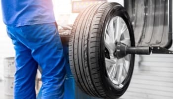 Professional car tire replacement being performed on a vehicle.