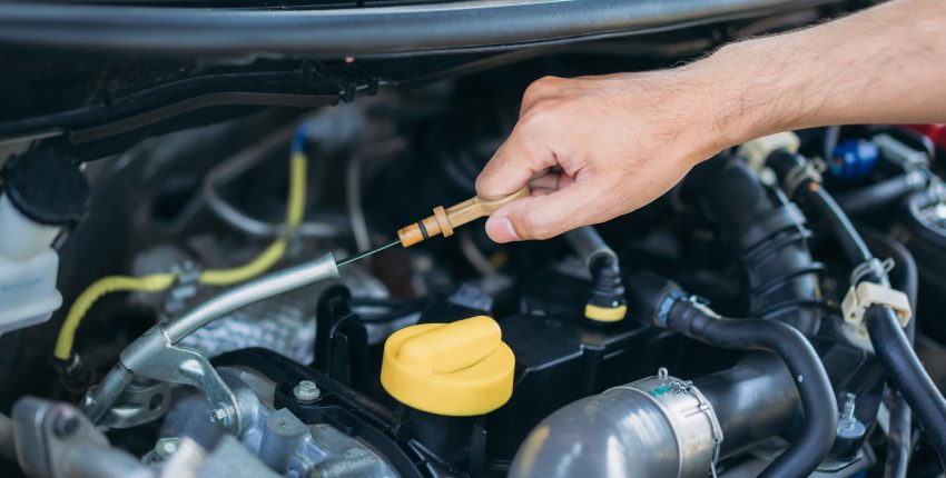 Mechanic checking oil level in car engine in Nashville.