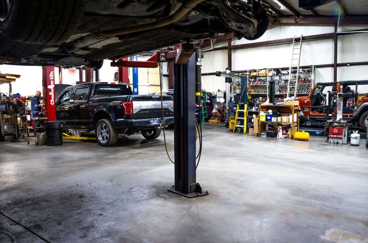 Automotive repair shop with vehicle lift and tools for car maintenance.
