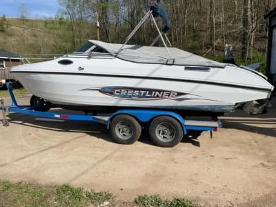 Boat on trailer at The OTTO Shop, specializing in boat sales and repairs.