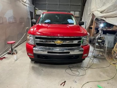 Red Chevrolet Silverado front view in a garage setting.