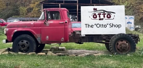 Vintage red truck with The OTTO Shop sign, ideal for home decor and custom signage.