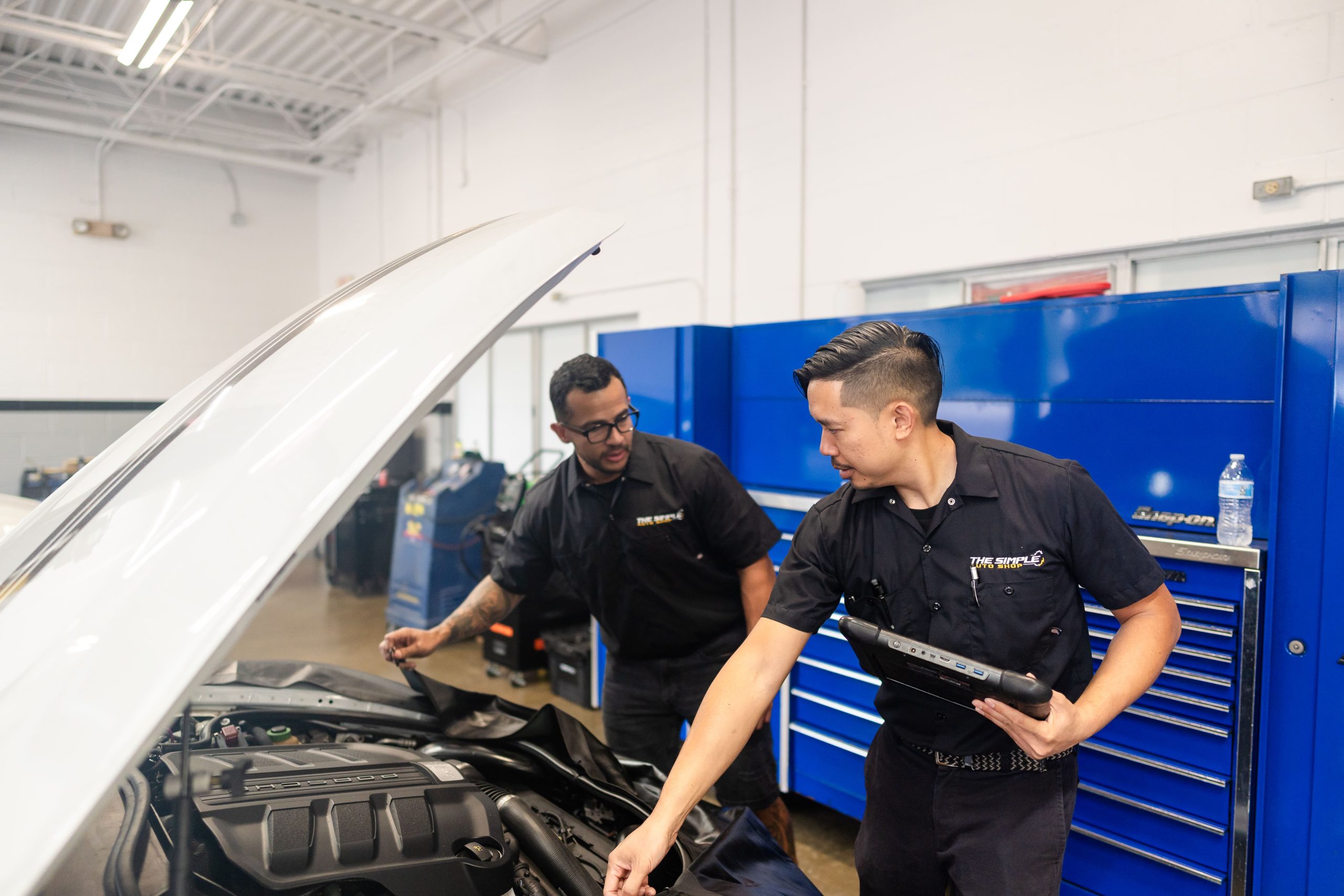 Auto repair technicians diagnosing car engine issues at The Simple Auto Shop.