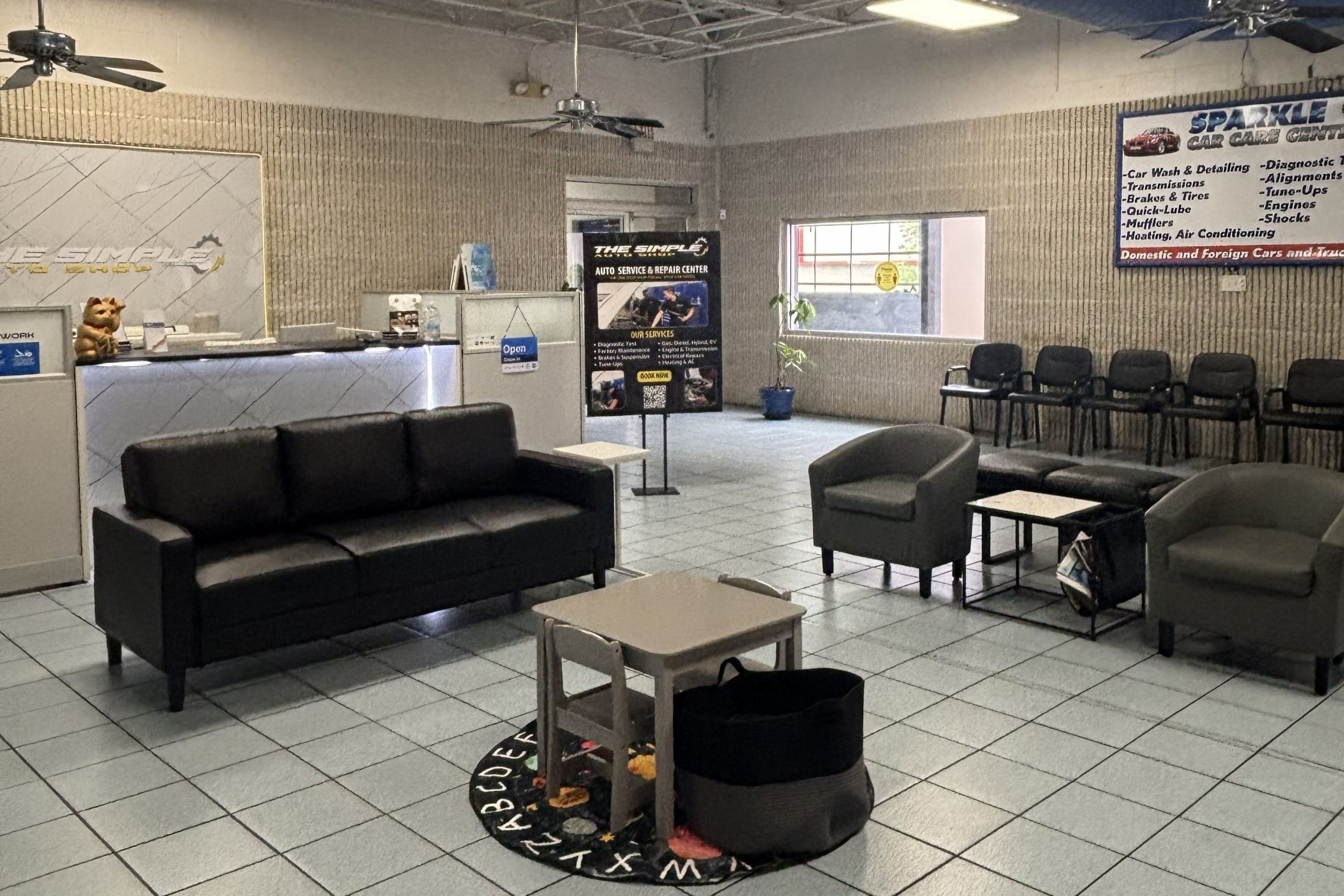 Modern car service waiting area with comfortable seating and informational displays.